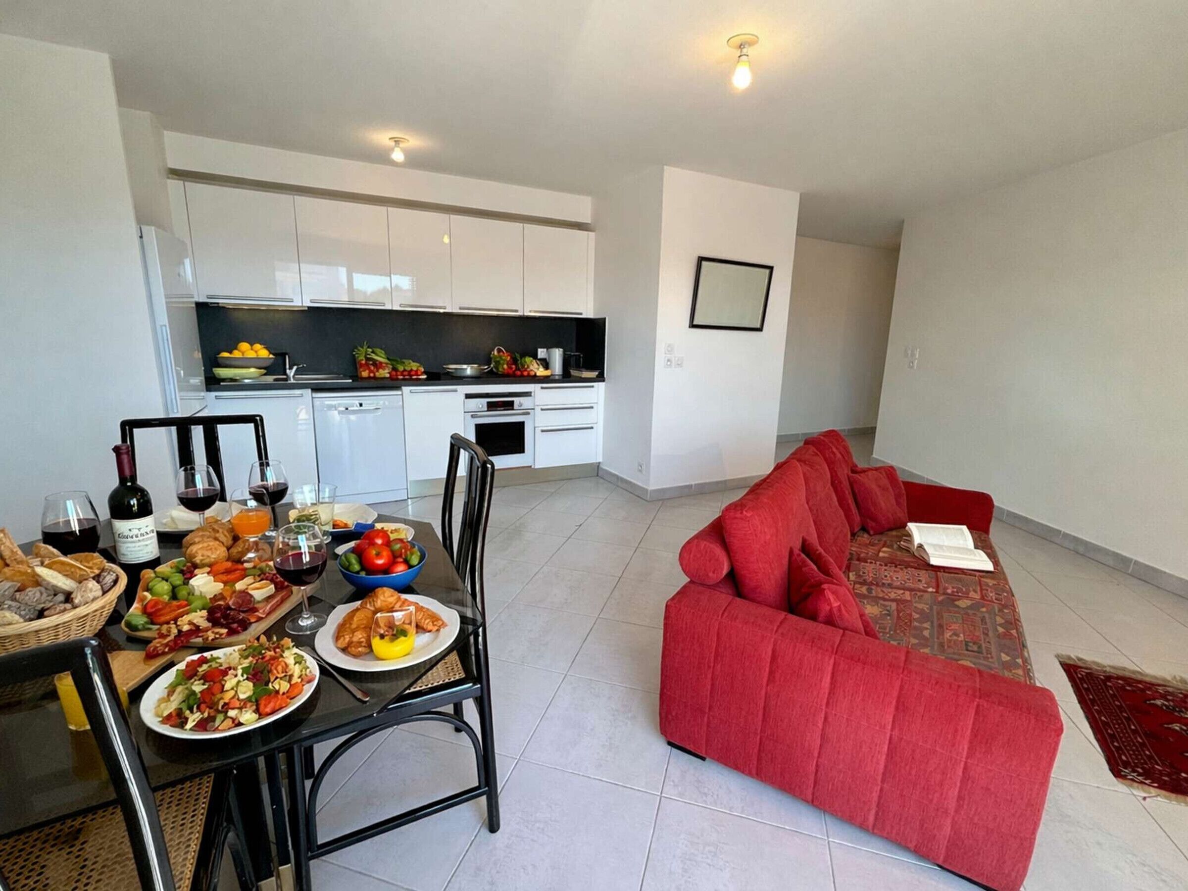 A modern apartment with a dining area, kitchen, and living room.