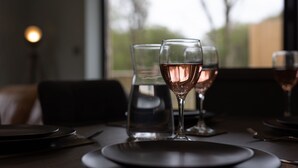 A dining table with plates, glasses, and a candle. - Fig Tree Cottage (Tenby)