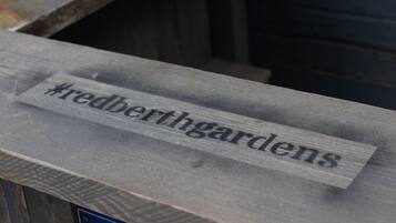 A wooden sign with the hashtag #redberthgardens.