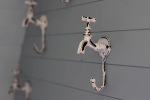 Una pared con varios ganchos metálicos.