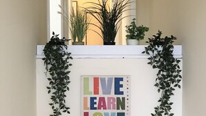 Un mur orné d’une citation inspirante et de plantes en pot.
