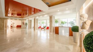 A spacious lobby with a high ceiling, marble flooring, and a reception desk. - Bright Apartment with Front Sea Views (Marbella)