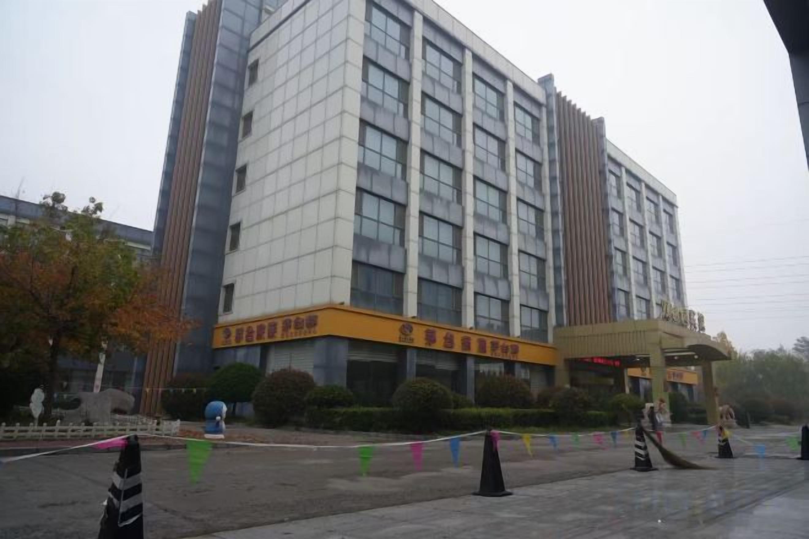 A multi-story building with a prominent entrance and a covered area.