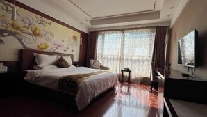 A hotel room with a large bed, a television, a desk, and a window with curtains. - Gaoqing Shuangchuangyuan Hotel (Gaoqing)