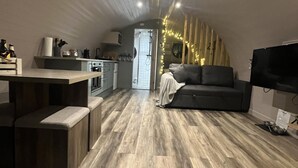 Un espacio habitable moderno con cocina, sofá y televisor.