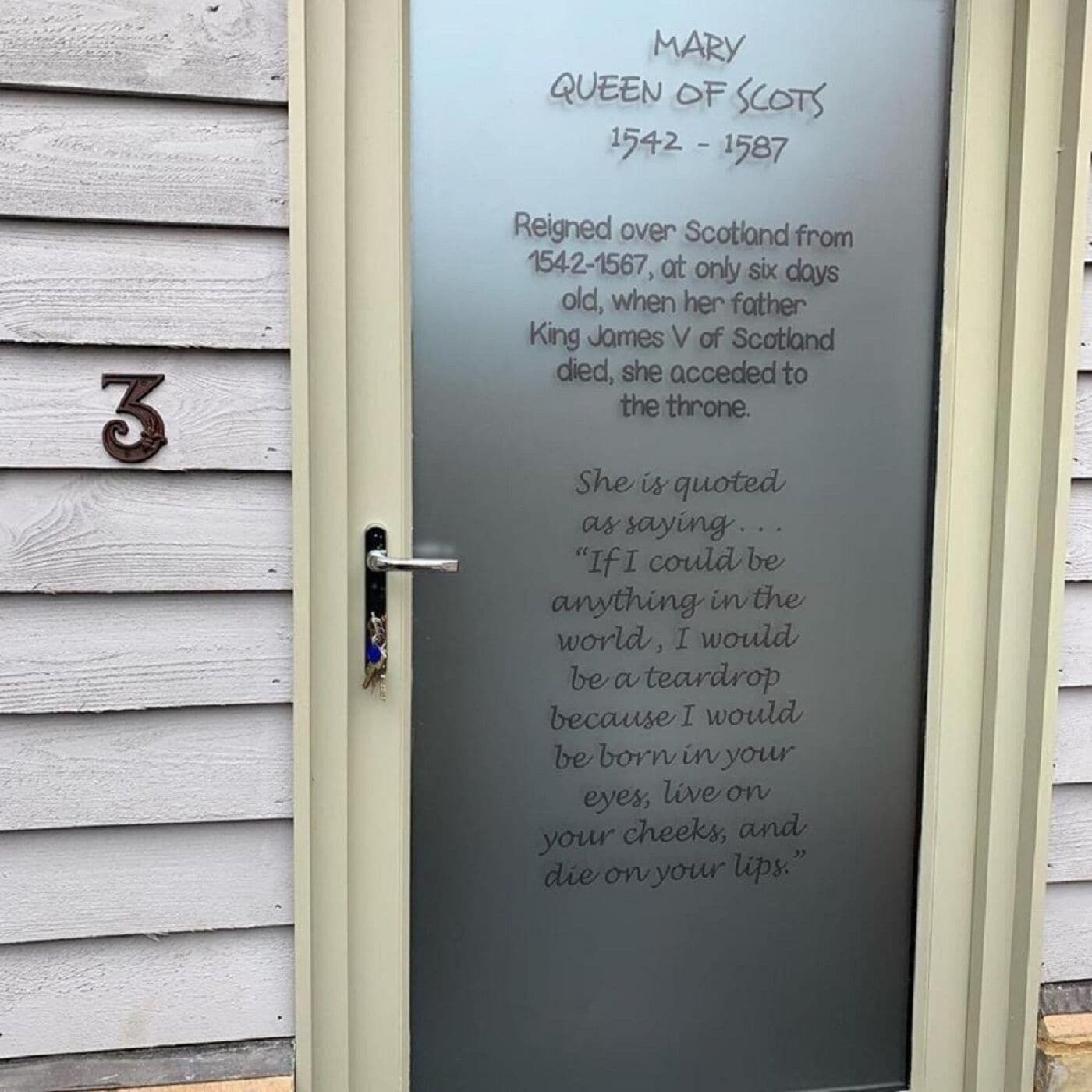 A door with a historical plaque about Mary, Queen of Scots, and a number '3' on the door frame.