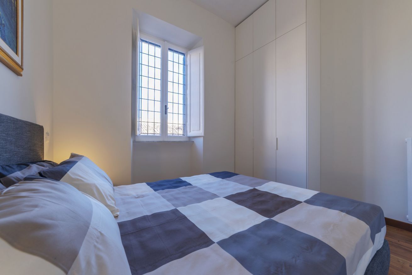 Ein Schlafzimmer mit Bett, Fenster und Kleiderschrank.