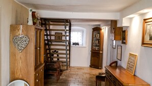 A hallway with a wooden cabinet, a mirror, and a staircase leading to another room. - The Jura House 1540 - a vacation in a monument on the Danube Cycle Path (Pförring)
