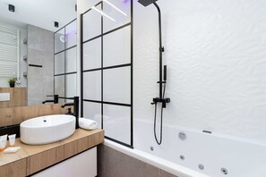 Bathtub, hair dryer, towels, shampoo