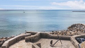 A stone pier with an anchor, overlooking calm sea waters and a clear sky. - Rock Point Inn (Lyme Regis)