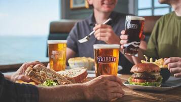 Una mesa de comedor con comida, bebidas y gente.