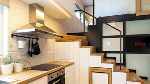 A modern kitchen with a wooden countertop, stainless steel range hood, and a built-in oven.