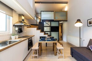 A compact kitchen with a dining area, a staircase, and a sofa. - Modern House close to Rethymno (Violi Charaki)