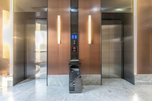 An elevator with a digital control panel, marble flooring, and wooden paneling. - Tuke China Hotel (Fuding Central Plaza) (Fuding)