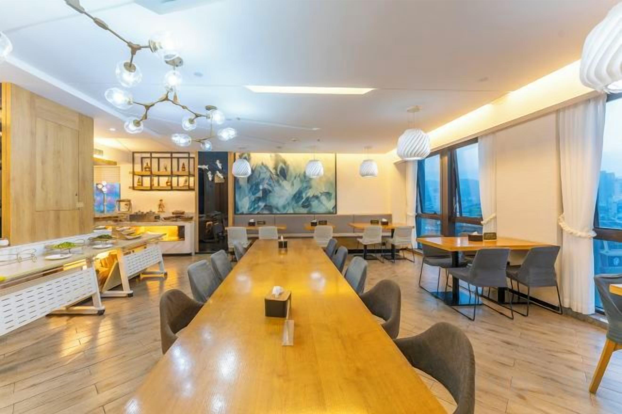 Una sala de conferencias moderna con una larga mesa, varias sillas y vistas a la ciudad.