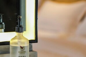 A bottle of hotel spa lotion with a pump dispenser, placed on a surface with a blurred background.