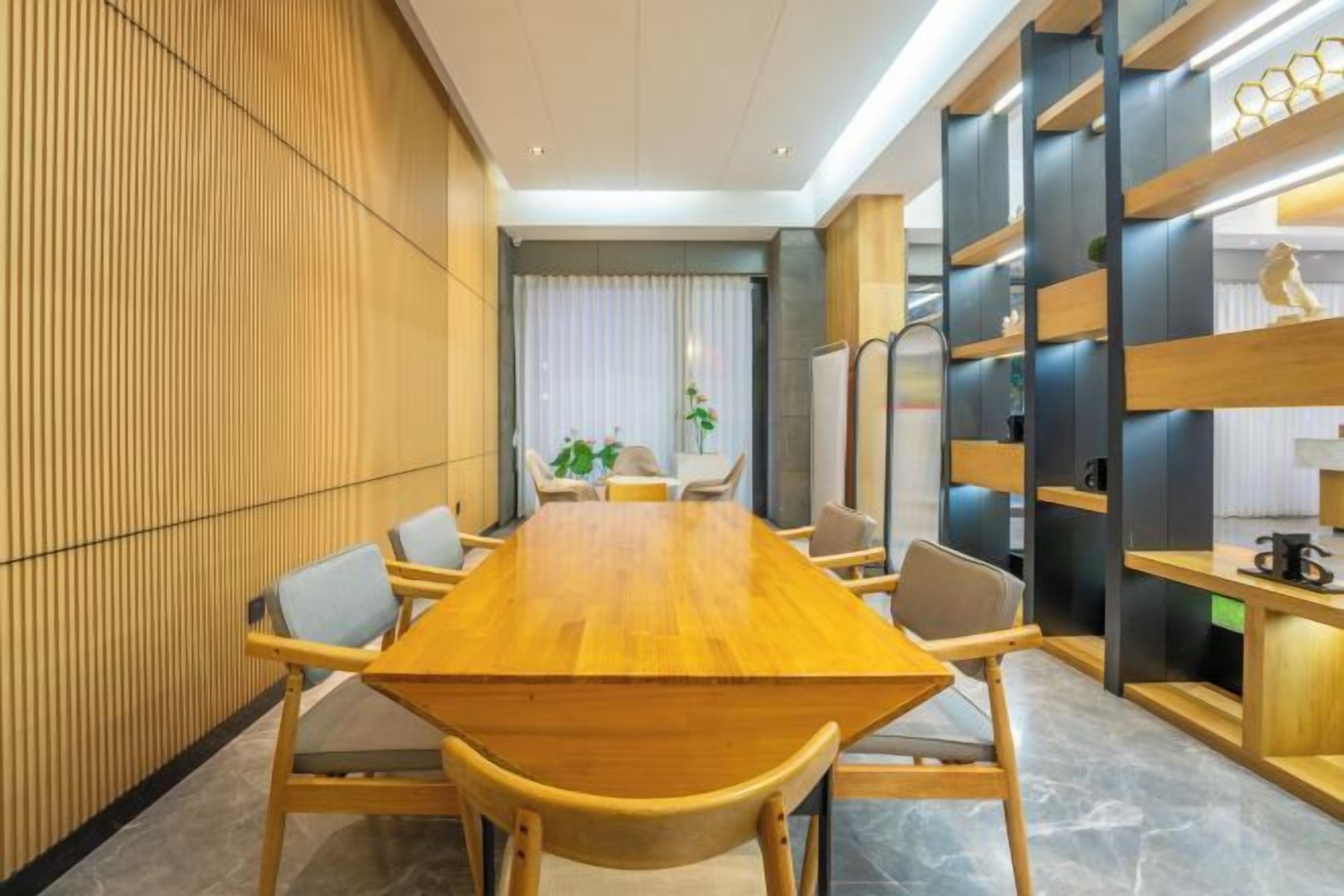 A conference room with a long wooden table, chairs, and a modern interior design.