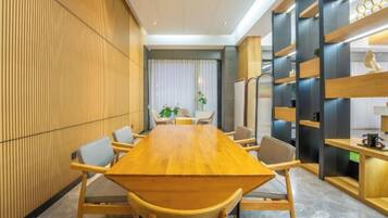 A conference room with a long wooden table, chairs, and a modern interior design.