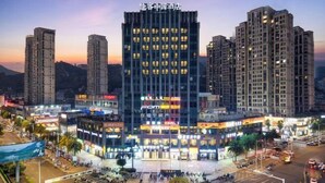 Un hotel de varios pisos con un atrio central, rodeado de edificios altos.