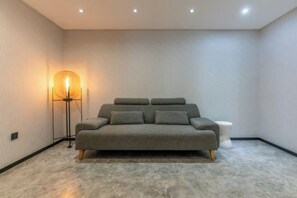 A modern bedroom with a sofa bed, a floor lamp, and a small bedside table. - Tuke China Hotel (Fuding Central Plaza) (Fuding)