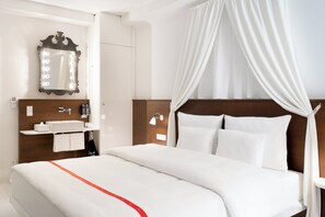 Une chambre d’hôtel avec un lit, une coiffeuse avec un miroir et une table de chevet.