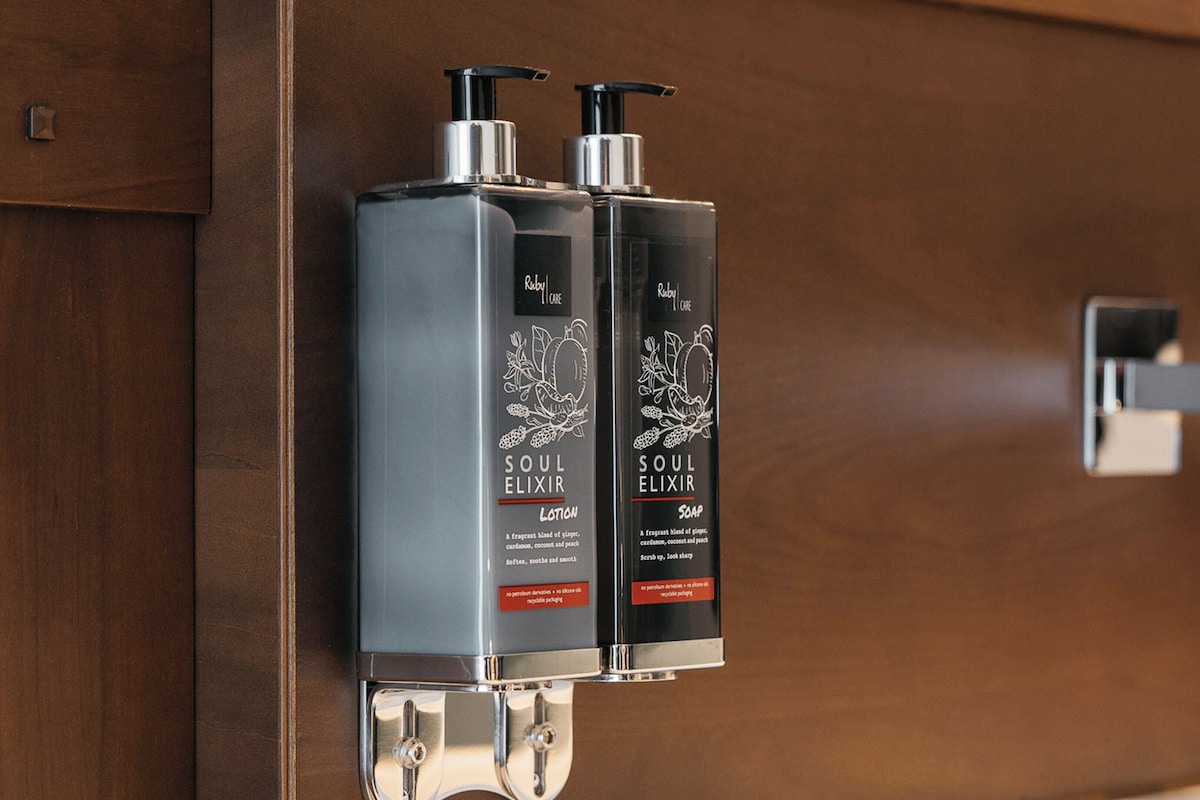 A restroom with two bottles of Soul Elixir lotion and soap.