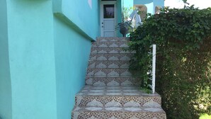 A staircase with patterned tiles leading to a door.