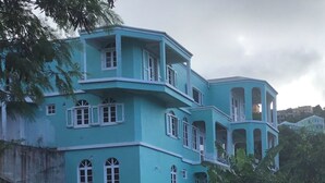 A multi-story building with a light blue exterior, multiple windows, and balconies.