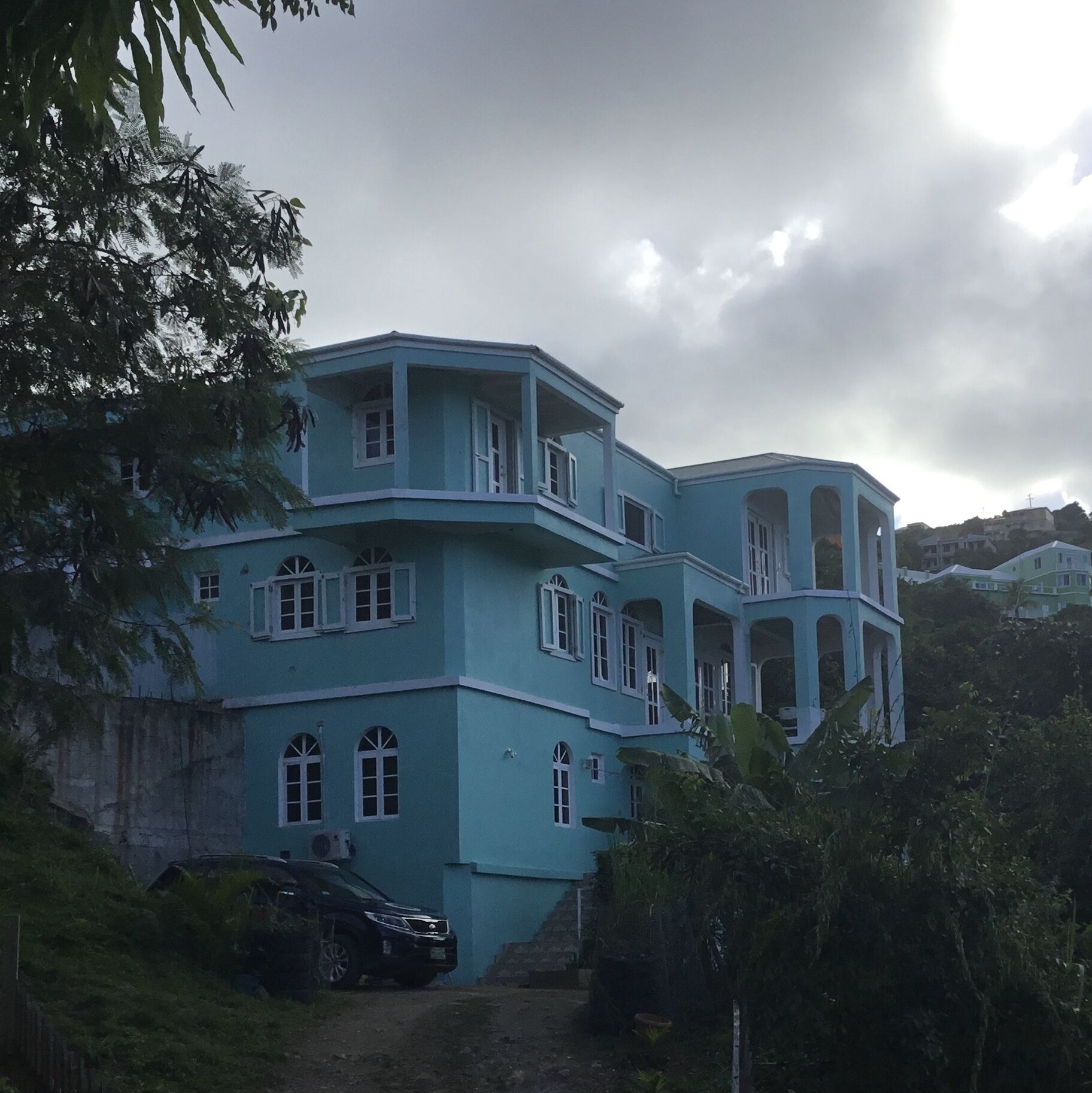 Um edifício grande e de vários andares, com fachada azul e várias janelas.