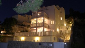Un edificio de varios pisos con balcones y fachada de piedra, probablemente un hotel o edificio residencial.