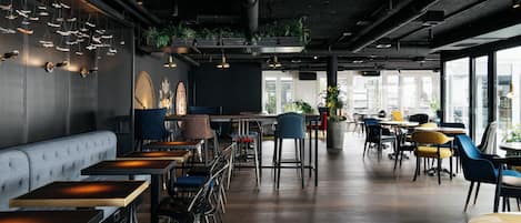 A modern interior with seating, tables, and large windows.