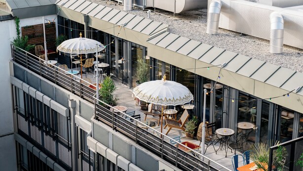 A rooftop terrace with outdoor seating, umbrellas, and potted plants. - Ruby Claire Hotel Geneva by IHG (Geneva)