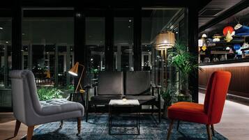 Un interior moderno con un sofá, un sillón y una lámpara de pie.