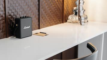 A white table with a black Marshall amplifier, a pencil, and a notebook.