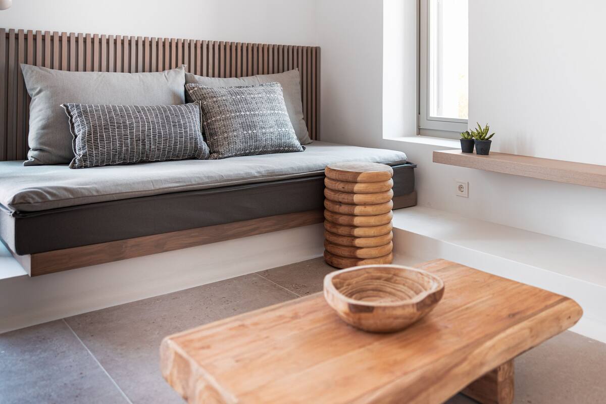 Una sala de estar moderna con un sofá, una mesita de madera y un cuenco.