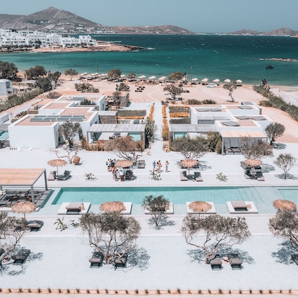A resort with a pool, sun loungers, and umbrellas.
