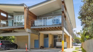 Un bâtiment moderne à deux étages, doté d’un toit plat, de grandes fenêtres et d’un balcon.