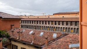 Un patio con techo de tejas, edificios de ladrillo y una grúa de construcción al fondo.