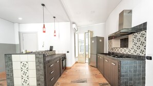 A modern kitchen with dark cabinetry, a central island, and patterned backsplash tiles.