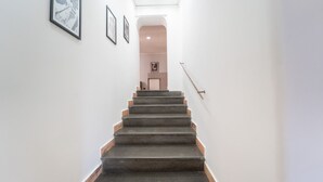 A staircase leading to a landing with framed pictures on the walls.