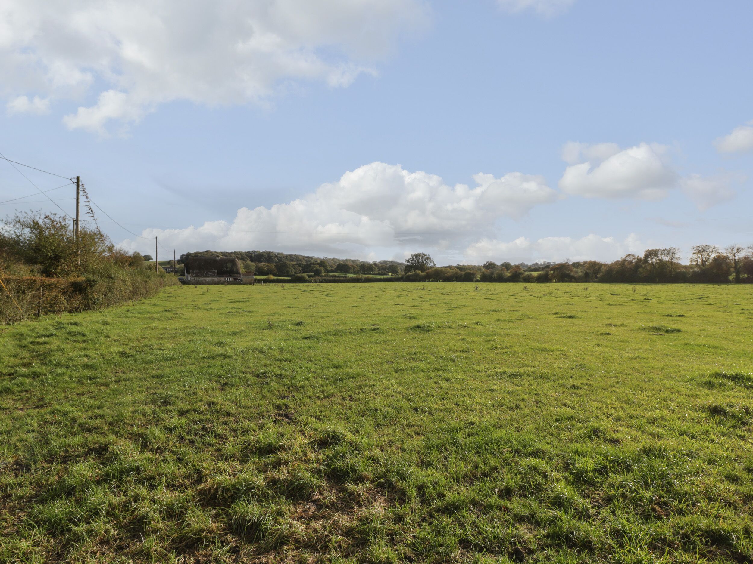 A wide, open field with a building in the distance.