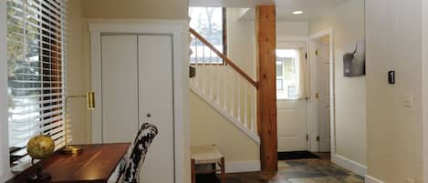 Staircase leads to an upper level, with a dining area featuring a wooden table and a globe centerpiece.