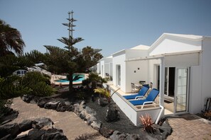Una villa moderna con piscina, mobiliario exterior y jardín ajardinado.