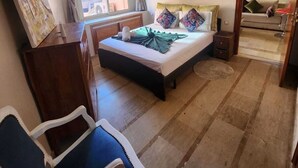 A bedroom with a bed, a desk, a chair, a window, and a mirror. - Appartement PATIO GUELIZ (Marrakech)