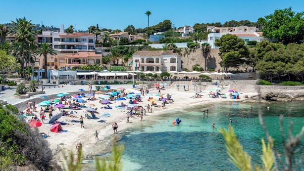 A beach with clear water, umbrellas, and people. - La Mar - By Almarina Villas (BENISSA)