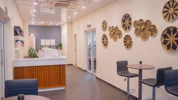 A reception area with a counter, chairs, and decorative wall art.