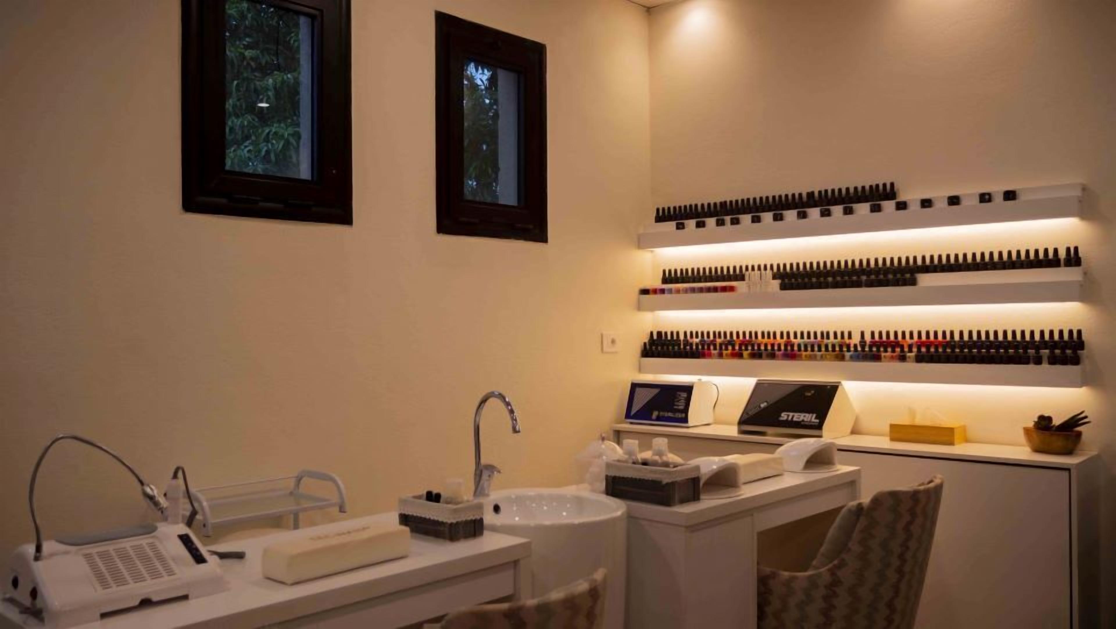 A well-lit bathroom with a sink, mirror, and shelves of toiletries.