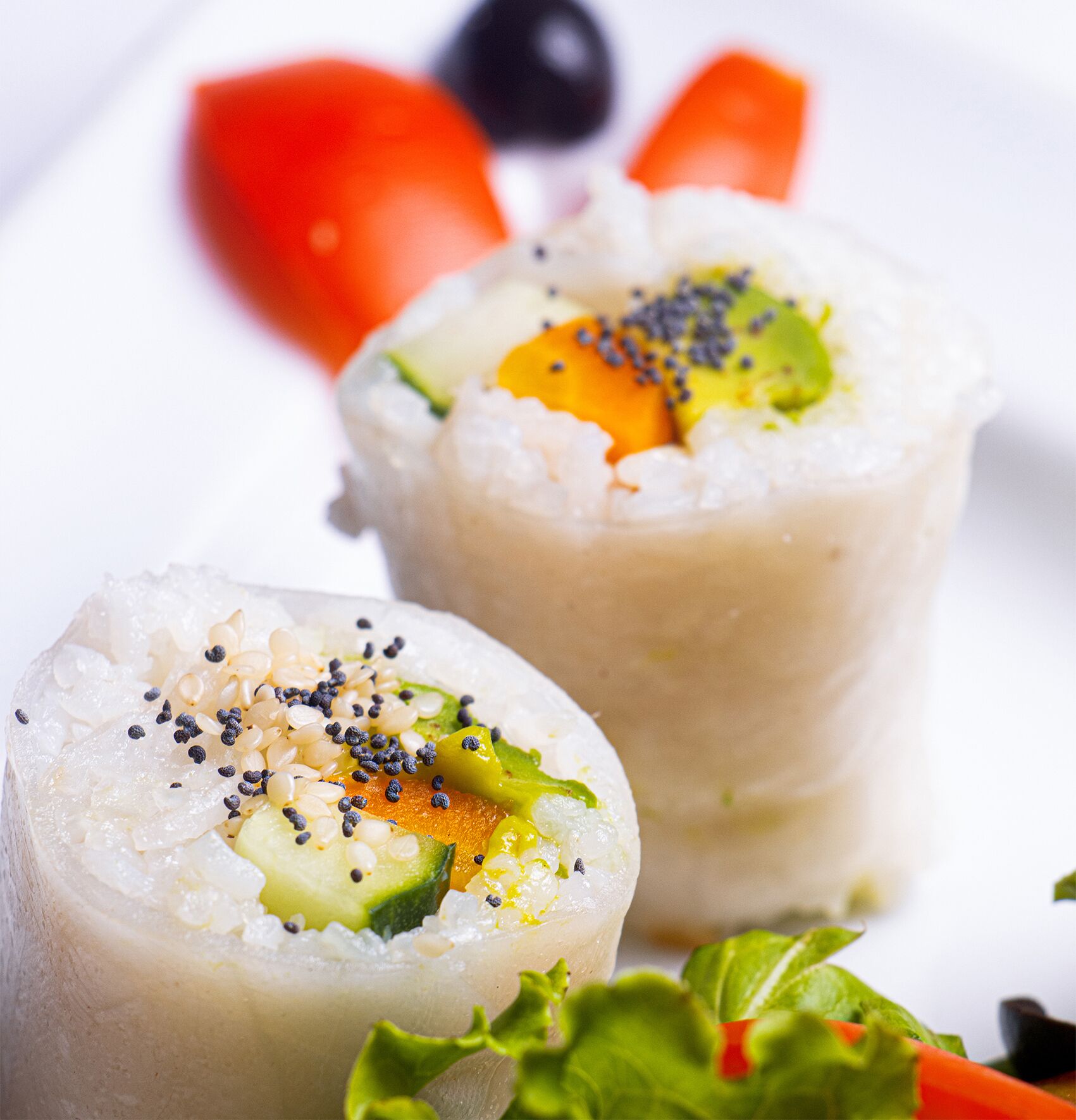 A close-up of a dish with rice, vegetables, and sesame seeds.