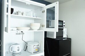 Una cocina con microondas integrado, tostadora y hervidor.
