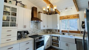 Eine moderne Küche mit weißen Schränken, Holzboden und einem eingebauten Herd.